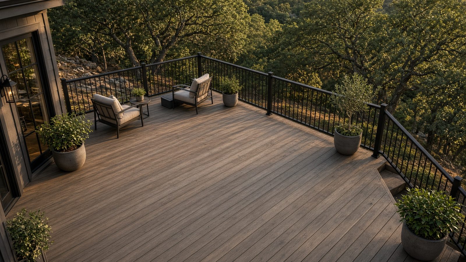 Cedar deck with black railings and lounge chairs under live oaks